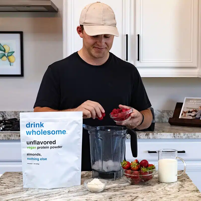 making-a-drink-wholesome-vanilla-meal-replacement-powder-shake a man making a protein shake with drink wholesome protein powder